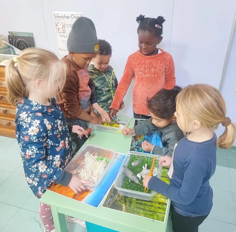 A group of children exploring a sensory water table together