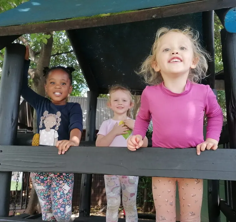 Children laughing on a wooden play structure