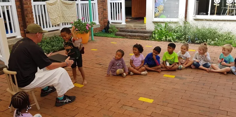 Children sitting in a row outdoors during a karate session